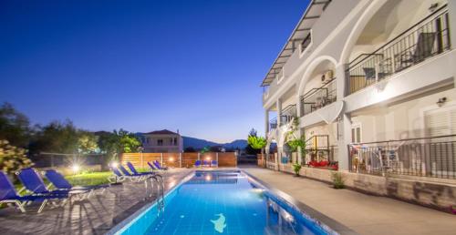 una piscina frente a un edificio con sillas en Brunswick Villa Units Party & Wedding Complex by "elite", en Laganas