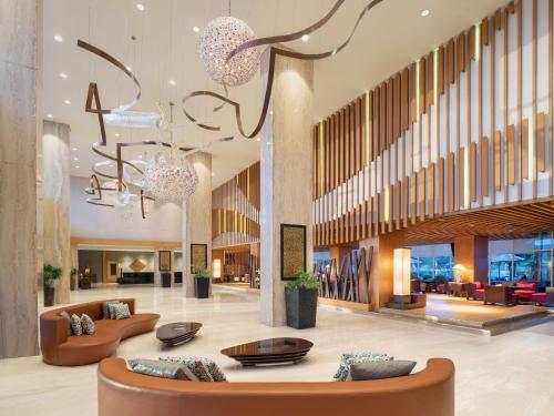 a lobby with couches and chairs in a building at Radisson Golf & Convention Center Batam in Batam Center