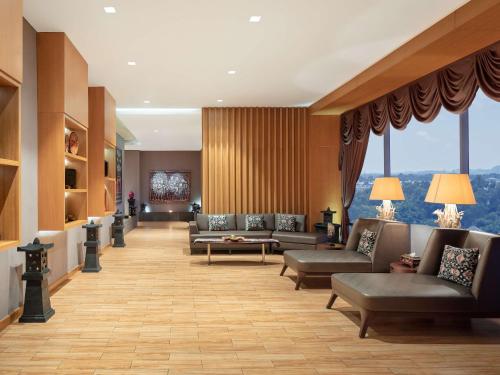 a lobby with couches and tables and windows at Radisson Golf & Convention Center Batam in Batam Center