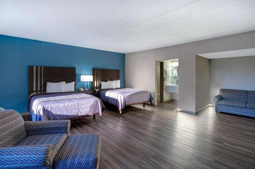 a hotel room with two beds and a couch at Motel 6 Burlington in Burlington