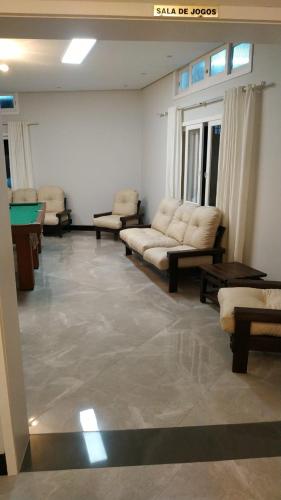 a living room with couches and a pool table at Hotel Kruger in Tramandaí