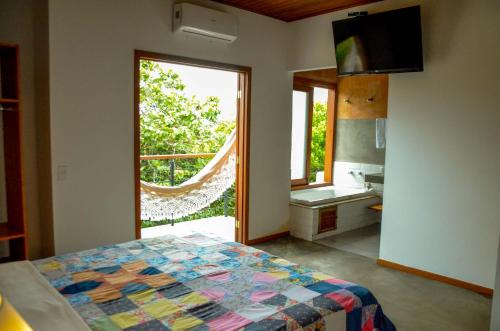 um quarto com uma cama e uma grande janela em Serra do Juá Pousada de Campo em Pirenópolis