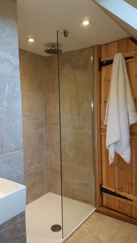 y baño con ducha y puerta de cristal. en Gateshaw Cottage - Scottish Borders en Linton