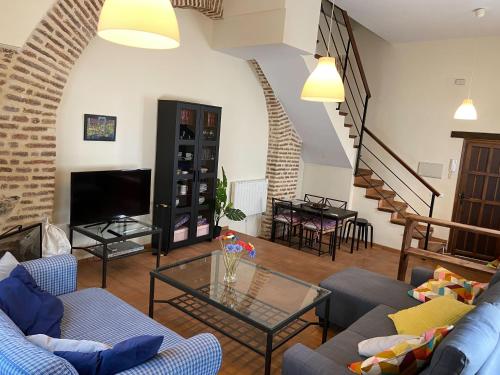 una sala de estar con sofás azules y una escalera. en Dúplex con piscina en centro Cazalla, en Cazalla de la Sierra