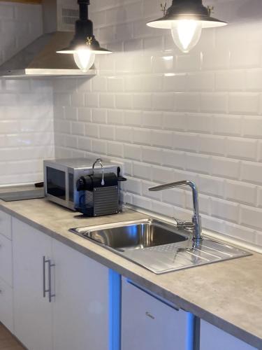 a kitchen counter with a sink and a microwave at Constância Guest House in Constância