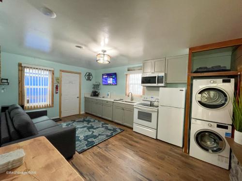 a living room with a couch and a kitchen at The Anchorage Motel in Pacific City