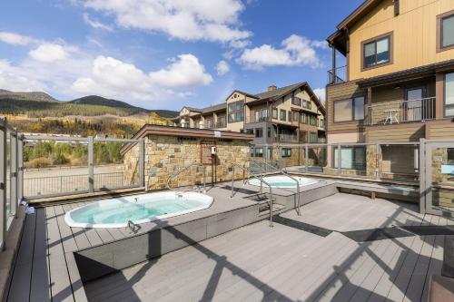 eine Terrasse mit Whirlpool und ein Gebäude in der Unterkunft 2754 Slopeside condo in Keystone
