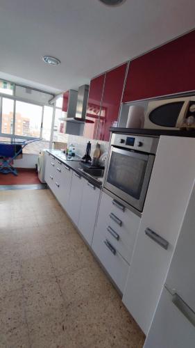 cocina con armarios blancos y microondas en Habitaciones en alquiler en piso compartido en Valencia