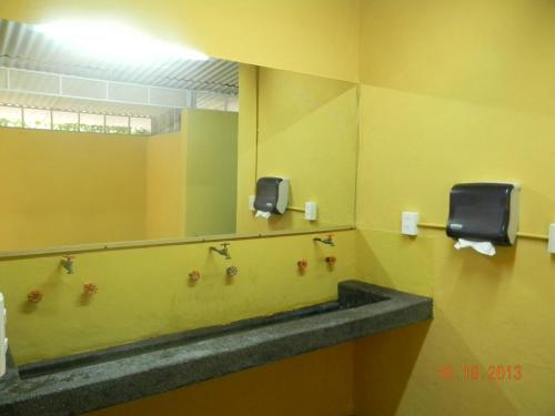 y baño con lavabo y espejo. en Tubohotel en Tepoztlán