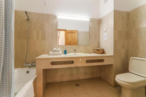 a bathroom with a sink and a toilet and a mirror at Apartamentos Ninho das Gaivotas in Albufeira