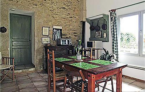 een eetkamer met een tafel en een groene deur bij Pet Friendly Home In St Jean Des Mauvrets With Kitchen in Saint-Mélaine-sur-Aubance