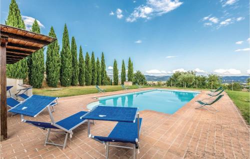 a swimming pool with blue chairs and a table at Seranna 1 in Papiano