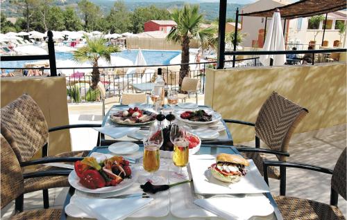 a table with plates of food on it with a view of a pool at Le Domaine De Fayence in Fayence