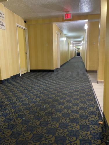 an empty hallway in an office building with an exit sign at Budget Inn Temple Hills in Temple Hills