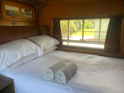 a bedroom with a bed with two towels on it at Platform One in Metung
