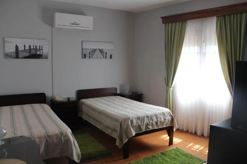 a bedroom with two beds and a large window at Restaurante Abba in Póvoa de Lanhoso