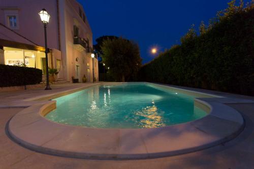 a swimming pool in the middle of a courtyard at night at Hotel Casino Ridola in Matera