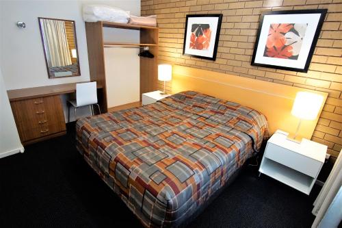 a hotel room with a bed and a bunk bed at Parkview Motor Inn and Apartments in Wangaratta