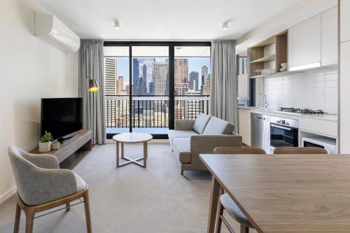 a living room with a couch and a table at Brady Apartment Hotel Hardware Lane in Melbourne
