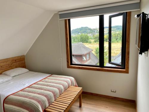 una camera con un letto e una grande finestra di Albergo B&B a Panguipulli
