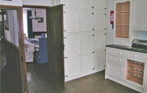 a kitchen with white cabinets and a counter top at Lovely Home In Chateauneuf Du Faou in Saint-Thois