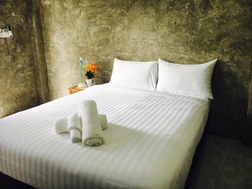 a white bed with two towels on top of it at Lanta smile inn in Ko Lanta