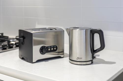 a toaster and a toaster sitting on a kitchen counter at Brady Apartment Hotel Hardware Lane in Melbourne