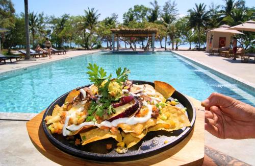 een bord eten op een tafel naast een zwembad bij BeachWalk Koh Rong in Koh Rong Island