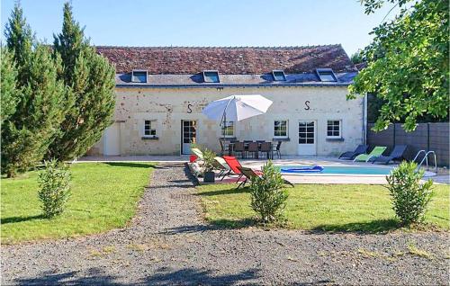 a house with a table and an umbrella in the yard at Nice Home In Thilouze in Thilouze