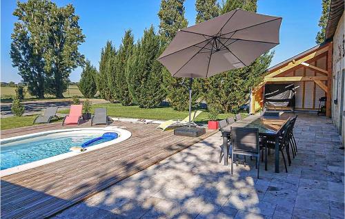 a patio with a table and an umbrella next to a pool at Nice Home In Thilouze in Thilouze
