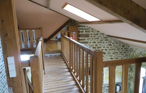 a wooden staircase in a house with a stone wall at 2 Bedroom Cozy Home In La Dorée in Couesmes-en-Froulay