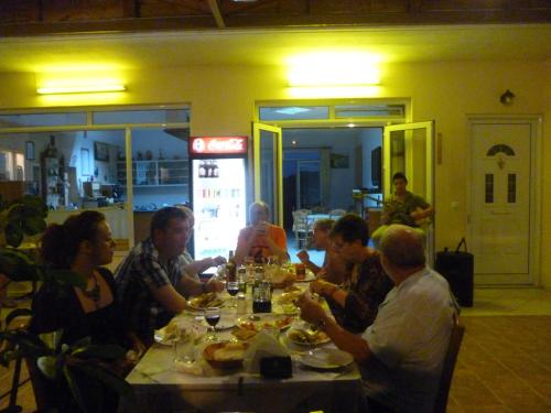 un grupo de personas sentadas en una mesa comiendo en LICHNOS Babis Taverna & Rooms, en Parga