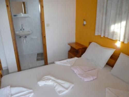 Un baño con una cama con dos toallas. en LICHNOS Babis Taverna & Rooms, en Parga