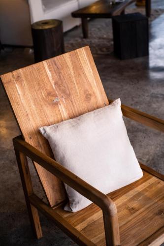 a wooden chair with a pillow in a room at The Hidden Paradise Ubud - CHSE Certified in Ubud