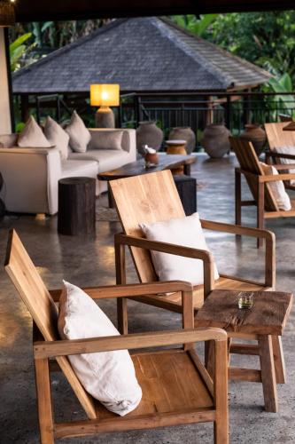 a group of chairs with pillows on a patio at The Hidden Paradise Ubud - CHSE Certified in Ubud