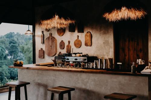 a kitchen with a counter with wooden utensils on the wall at The Hidden Paradise Ubud - CHSE Certified in Ubud