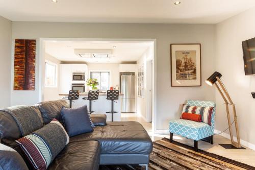 a living room with a couch and a chair at Private Cottage with Spa and Amazing Lake Views in Closeburn