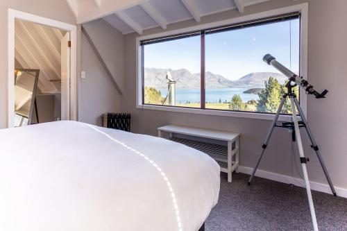 a bedroom with a bed and a telescope at Private Cottage with Spa and Amazing Lake Views in Closeburn