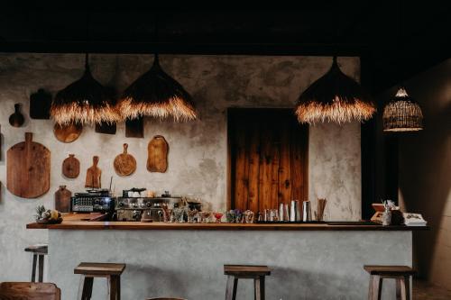 a kitchen with a counter with stools in a room at The Hidden Paradise Ubud - CHSE Certified in Ubud
