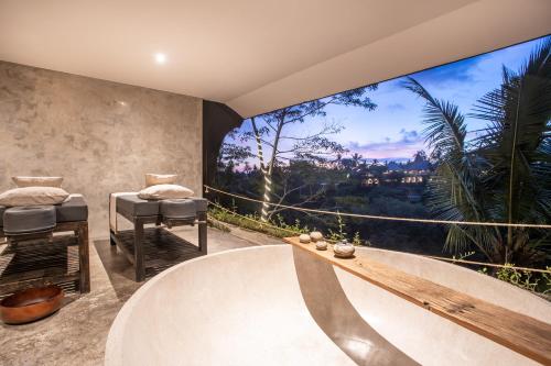 a bathroom with a tub and a large window at The Hidden Paradise Ubud - CHSE Certified in Ubud