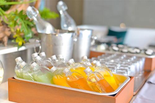 a container filled with bottles of orange juice on a counter at Shambhala Hotel Pattaya in Pattaya Central