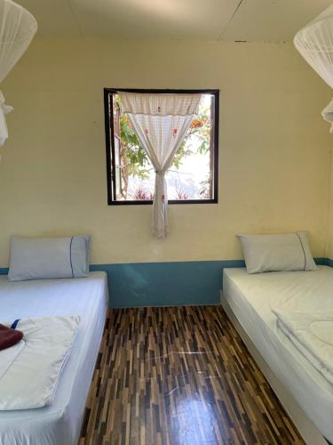 twee bedden in een kamer met een raam bij Pai Modern House in Pai