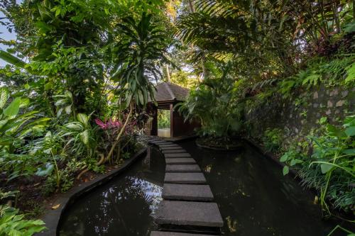 a garden with a pond and a small house at The Hidden Paradise Ubud - CHSE Certified in Ubud