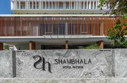 a sign on a wall in front of a building at Shambhala Hotel Pattaya in Pattaya Central