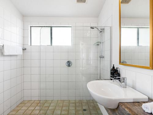 uma casa de banho branca com um lavatório e um chuveiro em Lighthouse Lodge em Byron Bay