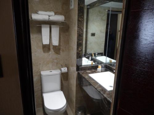 a bathroom with a toilet and two sinks and a mirror at Hotel Costa Pacifico - Express in Antofagasta