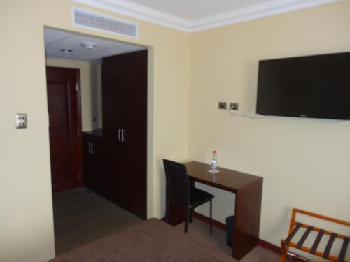 a room with a desk and a television on the wall at Hotel Costa Pacifico - Express in Antofagasta