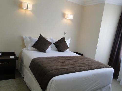 a hotel room with a large bed with two pillows at Hotel Costa Pacifico - Express in Antofagasta
