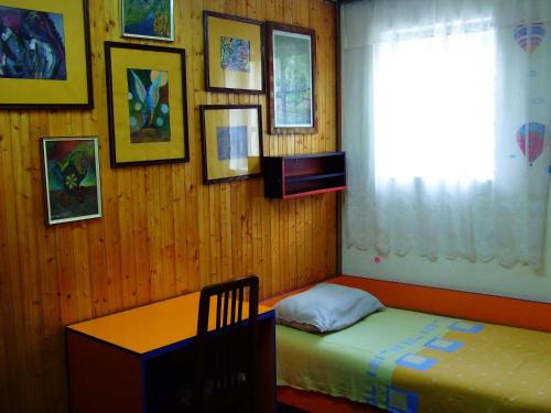 a bedroom with a bed and a table and a window at Hostel Domestika in Bitola