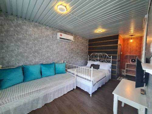 ein Wohnzimmer mit einem Sofa und einem Bett in der Unterkunft Cheqma Tiny Chalet in Kota Bharu